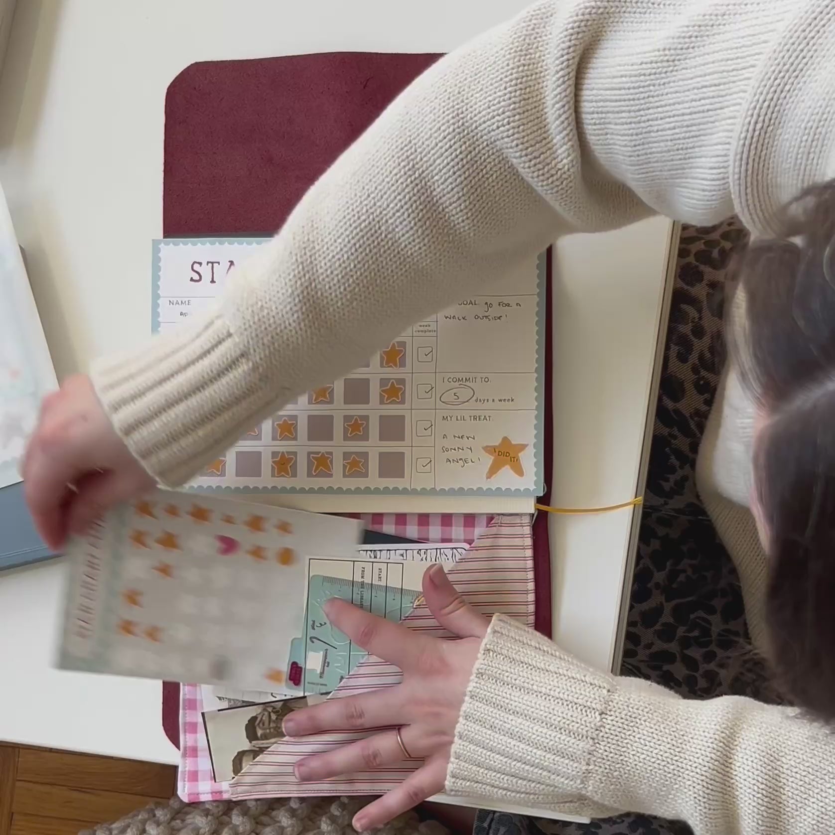a girl replacing the completed star chart in her journal with a new star chart and a new goal